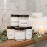 Jars of Lollipop Pop Truffles bath soaps and milk baths on a wooden stand with a colorful floral background.