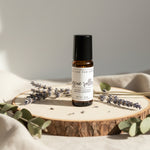 Row of small jars and bottles with labels on a wooden shelf.