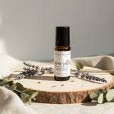 Row of small jars and bottles with labels on a wooden shelf.