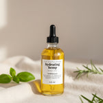 Bottle of hydrating hemp body oil on a neutral background