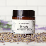 Jar of lavender magnesium cream on a white surface with lavender flowers.