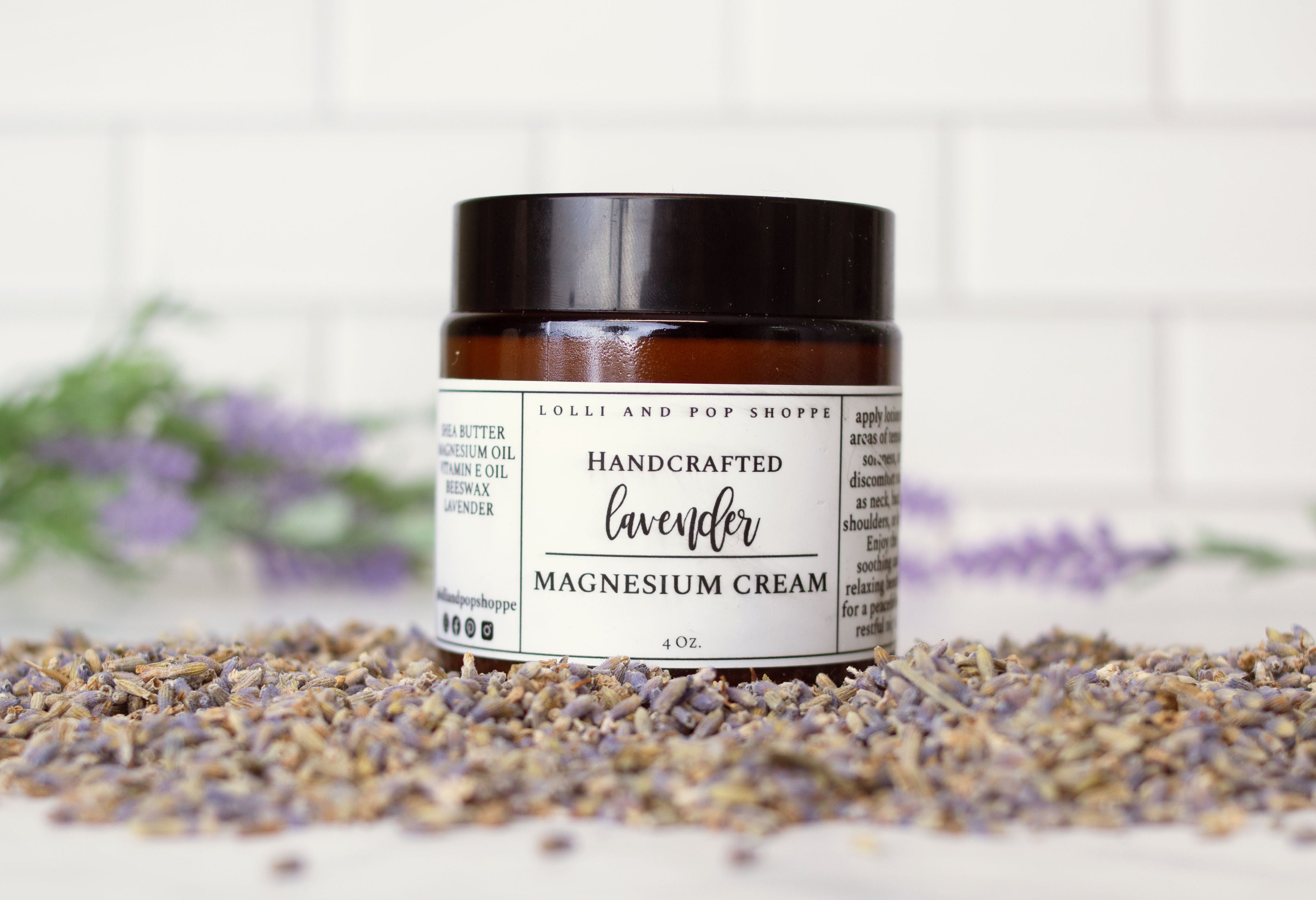 Jar of lavender magnesium cream on a white surface with lavender flowers.