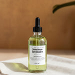 Set of skincare bottles on a tray with a white orchid in the background
