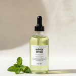 Set of skincare bottles on a tray with a white orchid in the background