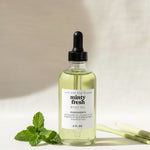 Bottle of minty fresh aloe oil with a dropper on a neutral background