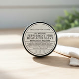 Peppermint pine headache salve container with label on a wooden surface