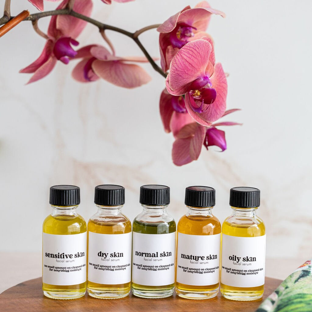 five bottles of essential oils sit on a wooden tray