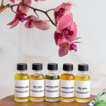 five bottles of essential oils sit on a wooden tray